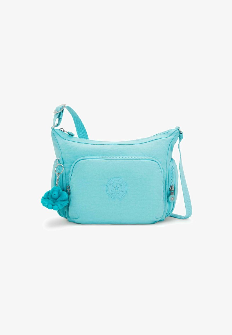 Borsa in tessuto turchese con una tasca principale con zipper, tasca frontale e tracolla regolabile; presenta un portachiavi a forma di personaggio blu peluche.