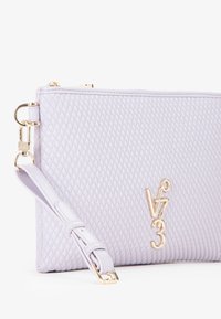Clutch trapuntato lavanda chiaro con finiture in oro, dotato di una tracolla removibile e dettagli con logo impresso. Texture liscia e forma rettangolare.