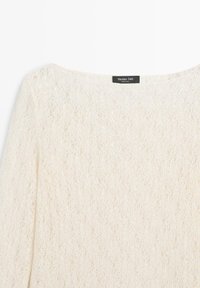 Cremefarbener Strickpullover mit lockerem, strukturiertem Muster und einem Massimo Dutti-Label am Halsausschnitt.