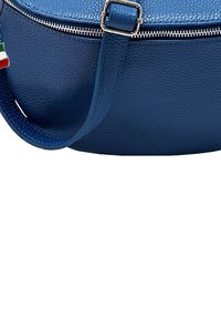 Donkerblauwe leren handtas met een textuurafwerking, voorzien van een zilveren rits en een hengsel met een decoratief vlaggetje. Ronde vorm.