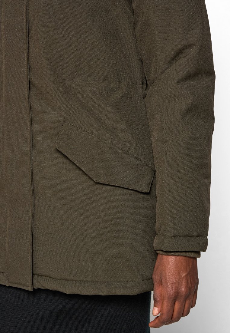 Veste rembourrée de couleur vert olive en tissu texturé, dotée d'une poche diagonale sur le côté gauche et d'un poignet. 