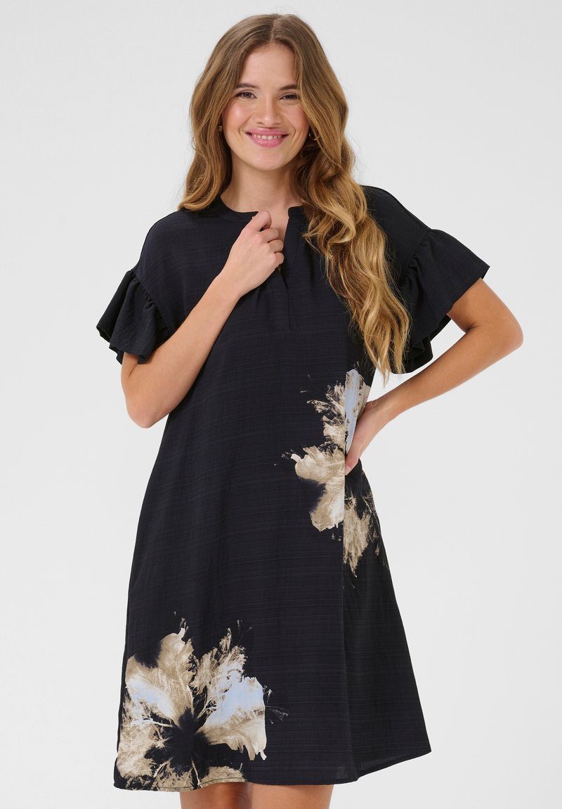 Schwarzes Kleid mit kurzen, gerafften Ärmeln, das ein gold- und blau-blumenmuster auf der unteren Seite zeigt. Textilstruktur, knielanger Schnitt.
