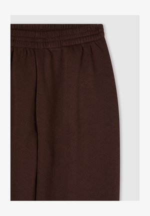 Pantaloni della tuta marroni con vita elasticizzata, realizzati in tessuto morbido. Vestibilità rilassata con cuciture laterali e senza dettagli o fantasie aggiuntive.