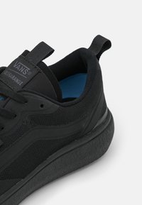 Baskets Vans UltraRange noires avec une tige en mesh, semelle en caoutchouc, accents texturés et col rembourré pour le confort. Semelle intérieure bleue visible.
