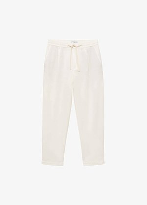 Jasne kremowe spodnie dresowe wykonane z miękkiego materiału, z elastycznym pasem ze sznurkiem, bocznymi kieszeniami i zwężającymi się nogawkami.