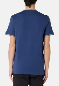 T-shirt blu a maniche corte con collo girocollo a costine. Presenta dettagli a righe contrastanti sulle maniche. Realizzato in un tessuto morbido e liscio.