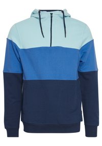 Mikina s kapucňou a polovičným zipsom, s farebným blokom v svetlo modrej, námorníckej a tmavšej modrej. Mäkká textura a predné vrecká.