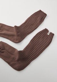 Manguitos castanhos de malha canelada feitos de tecido macio. Apresentam topos franzidos e uma pequena etiqueta da marca de um lado.