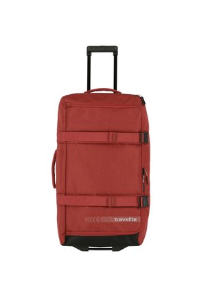 Red wheeled suitcase with a fabric surface, two carry handles, and compression straps; features a zippered front pocket and black accents.
