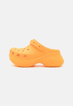 Orange gummistøvler har perforeret design, justerbar rem, rund tå og grov sål for forbedret komfort og stabilitet.