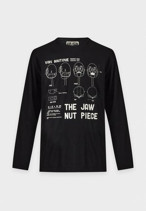 T-shirt noir à manches longues avec des schémas techniques blancs d’une mâchoire et le grand texte « The Jaw Nut Piece ».