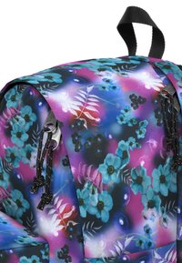 Batoh s květinovým vzorem v odstínech modré, levandulové a černé s lesklým povrchem, se černými stahovacími prvky a zipy.