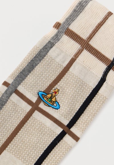 Μπεζ πλεκτό ύφασμα με καφέ, γκρι και μαύρες ρίγες και μικρή κεντημένη χρυσή σφαίρα με μπλε δαχτυλίδι και κόκκινες, πράσινες λεπτομέρειες.