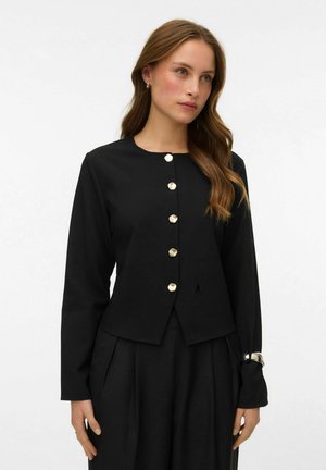 Veste noire sur mesure avec un col rond, six boutons dorés, et des manches longues s'évasant légèrement au poignet. Texture de tissu lisse.