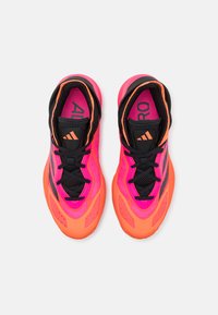 Scarpe da ginnastica di un vivace colore rosa e arancione con tomaia in rete, lacci neri e tre strisce nere. Suola semi-trasparente e collare imbottito.