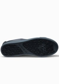 Svart gummisul med ett geometriskt slitbanemönster och präglad märkning. Har en mjuk kant och en strömlinjeformad form designad för komfort.