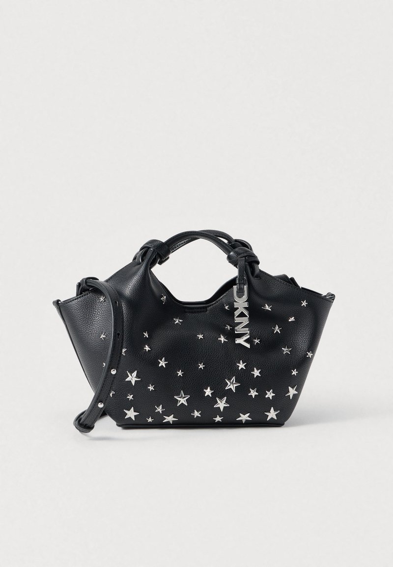 Sac à main en cuir noir orné d'étoiles argentées, avec une poignée supérieure et une bandoulière amovible. Comprend une étiquette avec logo. Surface texturée.