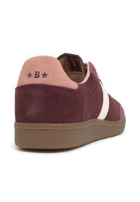 Zapatilla de ante en color burdeos y rosa con suela de goma, raya blanca en el lateral y logo de la "B" con estrellas en la etiqueta del talón.