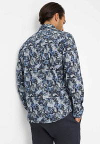 Bloemig overhemd in tinten van blauw en grijs, met een button-down kraag en lange mouwen met manchetdetails. Geverfd stof met een patroon van bloemen en bladeren.