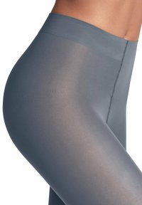 Leggings grigi con una texture liscia e opaca. Presentano una vita alta e una cucitura pulita lungo il lato, che migliora il design aderente.