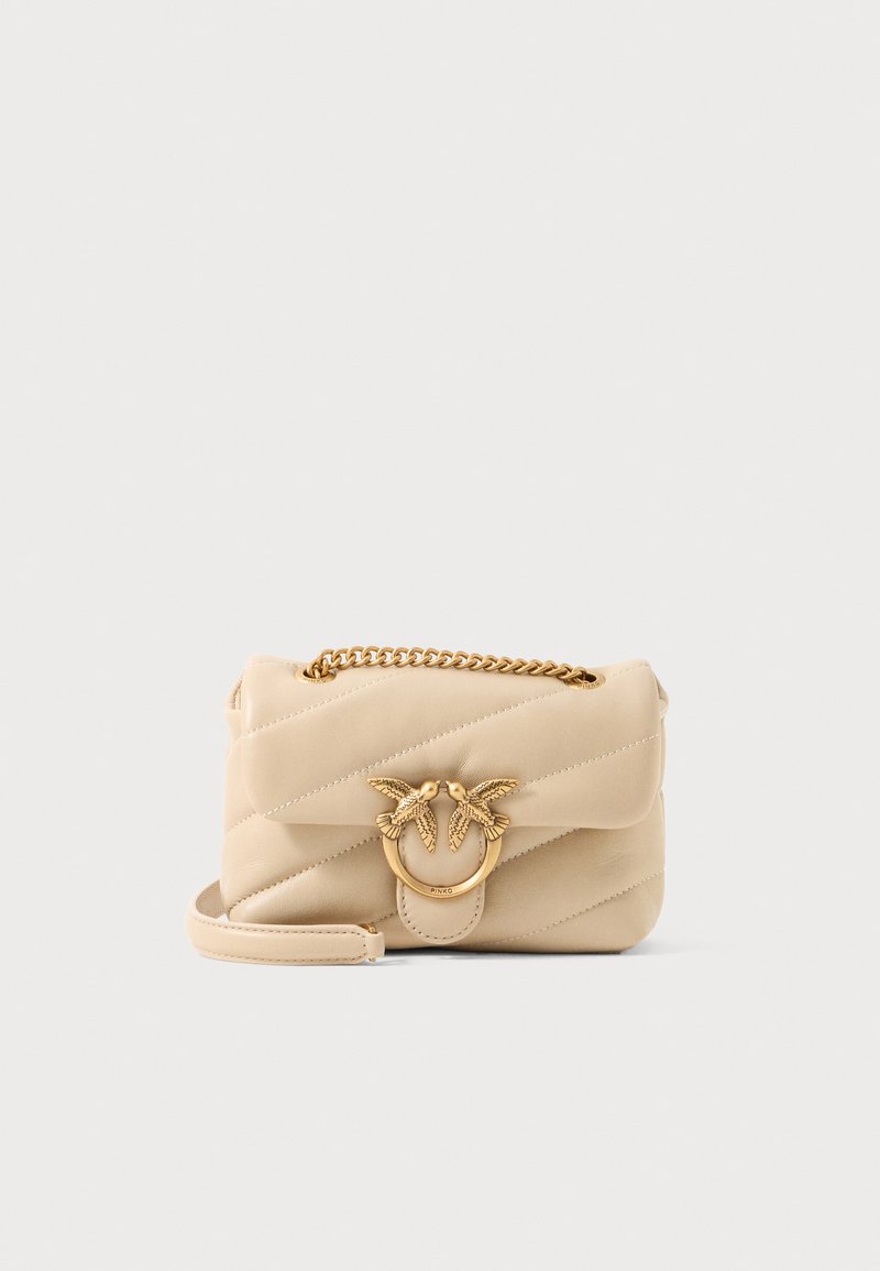 Borsa a tracolla in pelle trapuntata beige con catena dorata e un anello decorativo con dettagli di uccelli sul davanti.