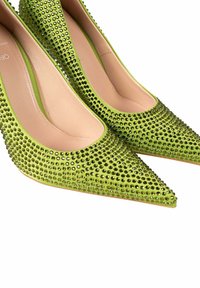 Zapatos de tacón alto verdes con un diseño de punta afilada, cubiertos de strass, con un interior suave y un exterior texturizado.