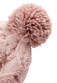 Rosa gestrickte Mütze mit einem großen, flauschigen Pompon an der Spitze, die ein strukturiertes Muster und dickes Garn für Wärme aufweist.