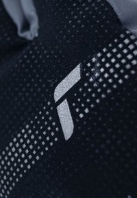 Schwarzer Stoff mit einem strukturierten Muster und einem metallischen silbernen Logo. Das Design umfasst geometrische Formen und unterschiedlich große Punkte.