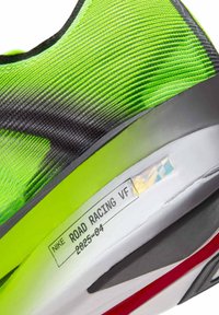 Nike Road Racing VF-schoen met een felgroene en zwarte, gestructureerde bovenkant, voorzien van een witte tussenzool en een rood accent op de buitenzool.