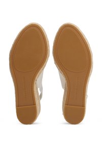 Λευκά εσπαντρίγια από καμβά με πλεγμένη διακόσμηση από γιούτα, ελαστικές σόλες από καουτσούκ και ανάγλυφο λογότυπο της μάρκας στη φτέρνα. Υφή στην κάτω πλευρά για καλύτερη πρόσφυση.