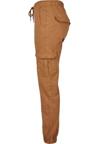 Pantalon cargo marron avec taille élastique, cordon de serrage, poches latérales avec rabat et poignets élastiques, vu de profil.