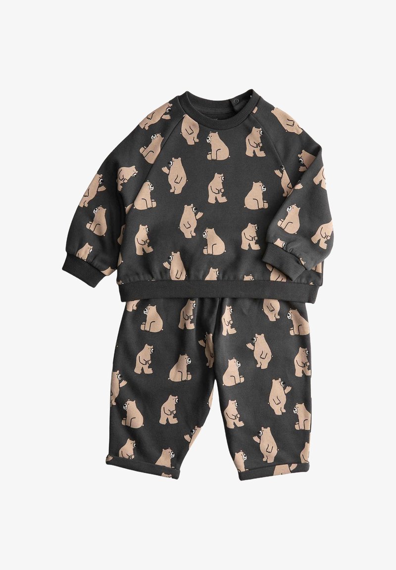 Conjunto infantil de dos piezas que incluye un sudadera negra y pantalones a juego, decorados con patrones de osos beige sobre una tela suave y texturizada.
