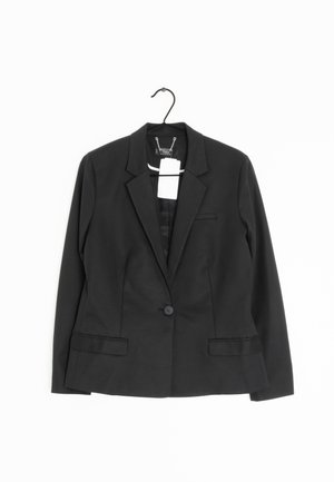 Czarny marynarka na jedno zapięcie z klapami, dwie przednie kieszenie z patkami, wisząca na czarnym wieszaku na białym tle z dołączonymi metkami cenowymi.