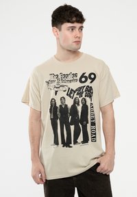 Beige cotton t-shirt featuring black graphic print of four musicians, with text "The Beatles," "Yellow Submarine," and "Abbey Road."