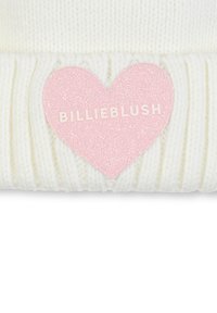 Witte gebreide beanie met een ribbelstructuur, voorzien van een roze glitter hartapplicatie met "BILLIEBLUSH" in witte tekst.