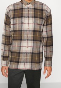 Braun-beiges kariertes Hemd mit Knopfkragen, zwei Brusttaschen und einer weichen Stoffstruktur. Enthält gelbe und rote Linien.