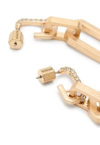 Orecchini in tonalità oro con design geometrico a catena, dettagli in cristallo trasparente, finitura metallica e elementi esagonali.