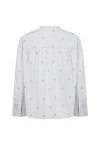 Camicia a maniche lunghe di colore azzurro chiaro con colletto. Presenta ricami in oro a forma di diamante su tutta la superficie e pieghe sul retro. Polsini con bottoni.