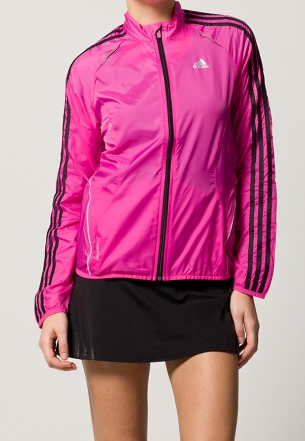 Chaqueta atlética ligera de color rosa con acentos negros, cierre delantero con cremallera, cuello alto y tres rayas negras en cada manga.