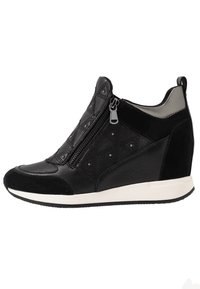 Svart kilsneaker med sidoglipa, kviltade läderdetaljer, små metallnitar och vit sula.