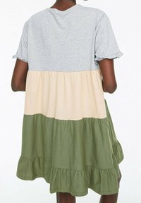 Robe grise à manches courtes avec un ourlet en volants, présentant une section médiane beige et une jupe vert olive, faite en tissu doux et léger.