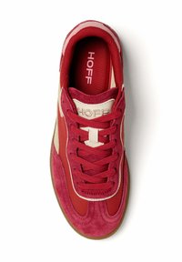 Red suede sneakers with a structured design, featuring contrasting beige accents, flat laces, and a round toe. The insole displays "HOFF."