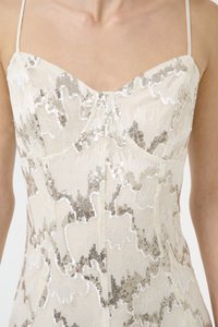 Kleit pitsikese kaeluse ja õrnalt beežil foonil lainetava hõbedase sädelusega, millel on õhukesed õlapaelad.