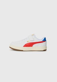 Baskets blanches avec des accents rouges et bleus, dotées d'une sangle velcro, d'un logo doré et d'une semelle en caoutchouc. Tige en cuir lisse avec des détails texturés.