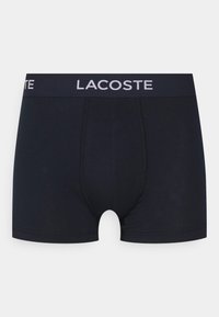 Mornarsko modri bombažni bokserici s tesnim prilegom, ki imajo bel "LACOSTE" logotip na elastičnem pasu in minimalne šivane detajle.