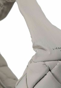 Jasnoszara torba z poduszką o pikowanym wzorze, z gładką fakturą i wyraźnym logo marki. Ergonomiczny uchwyt do łatwego noszenia.