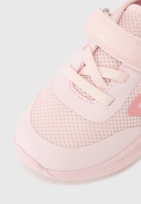 Růžová sportovní bota s vrchní částí z prodyšné síťoviny a syntetického materiálu, kulatou špičkou, šněrovacím designem a detailem na pásku. Lehká s texturovaným povrchem.