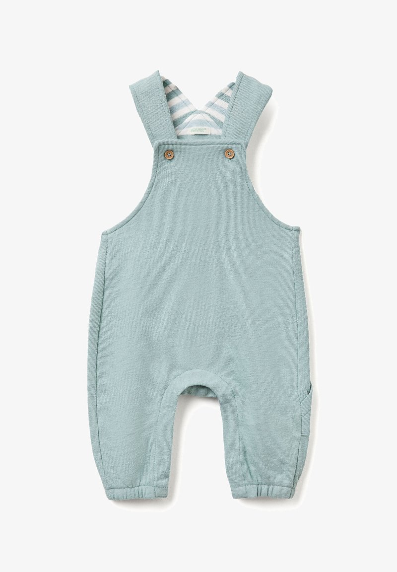 Peto de color azul claro, hecho de una tela texturizada, con tirantes cruzados, botones de madera y forro a rayas. Aperturas de piernas elásticas.