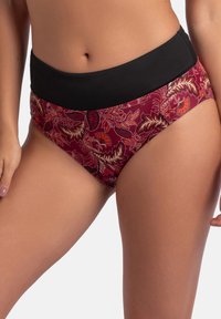 Bikini hlače visoko pasu z črnim pasom in rdečim materialom s cvetličnim vzorcem v rdečih in kremnih odtenkih.