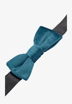 Teal fluwelen strik met een gestructureerd oppervlak, bevestigd aan een zwarte satijnen band. De strik heeft een centrale knoop en brede, ronde uiteinden.